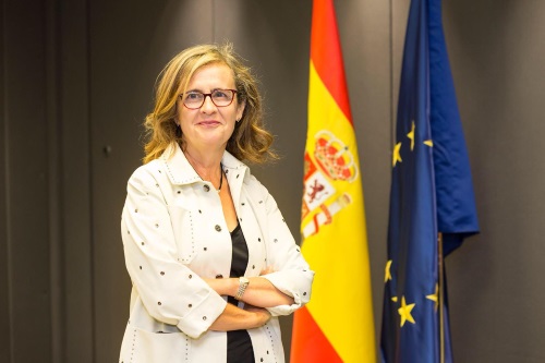 Maria Dolores Beato, consejera de la CNMV, primer plano con las bandera de España y europea